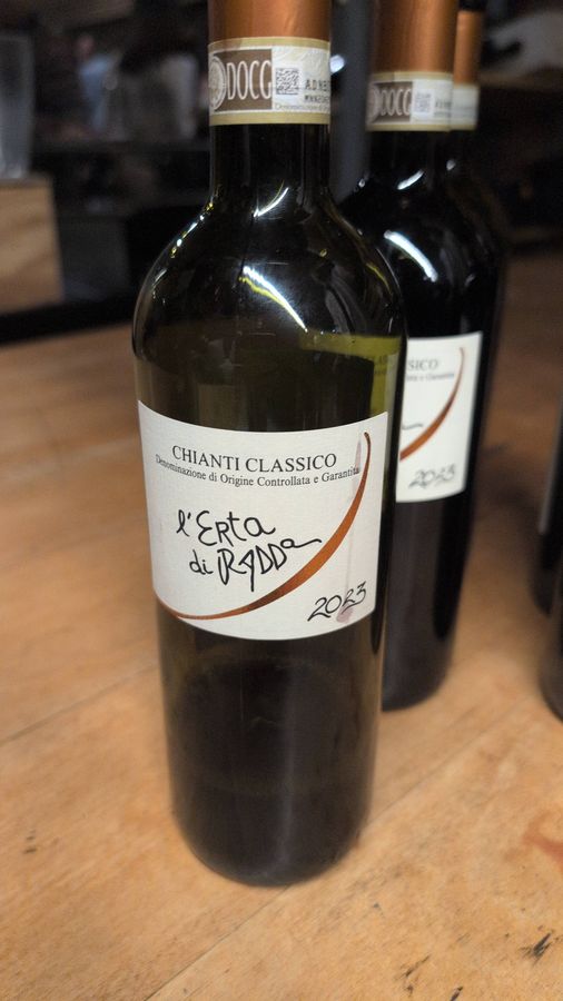 A bottle of L'Erta di Radda Chianti Classico 2023 on a wooden table