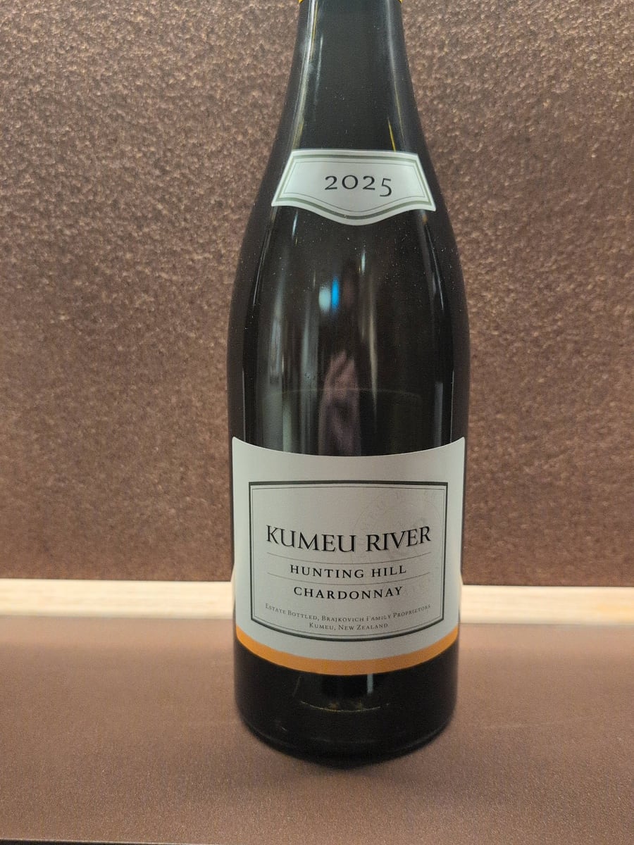 The Kumeu River Hunting Hill Chardonnay 2025 bottle, photographed against the textured wall of the tasting room